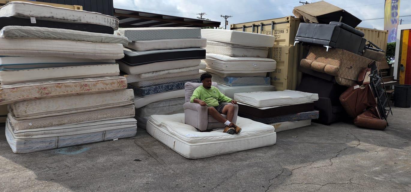 Stacks of mattresses and box springs at Duke's Junk Recycling yard for mattress removal and disposal in Austin, TX